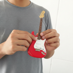 freepik__homem-segurando-uma-guitarra-miniatura-vermelha-co__73522